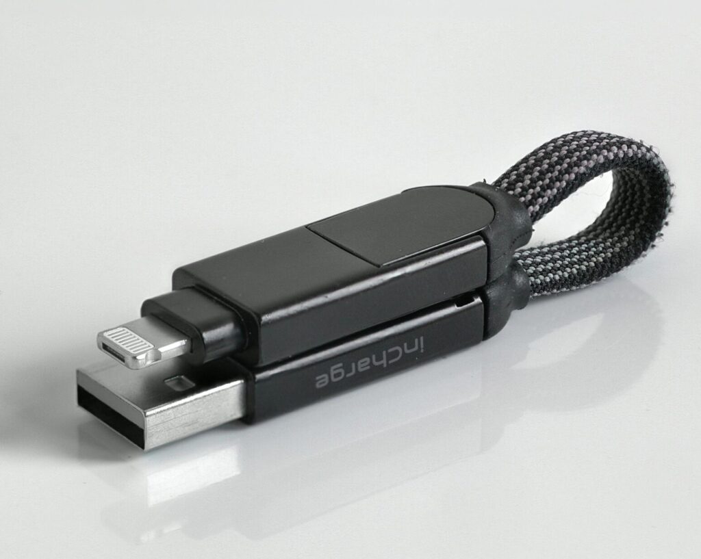 Minimalist photo of a sleek black USB flash drive with a braided loop against a white background.